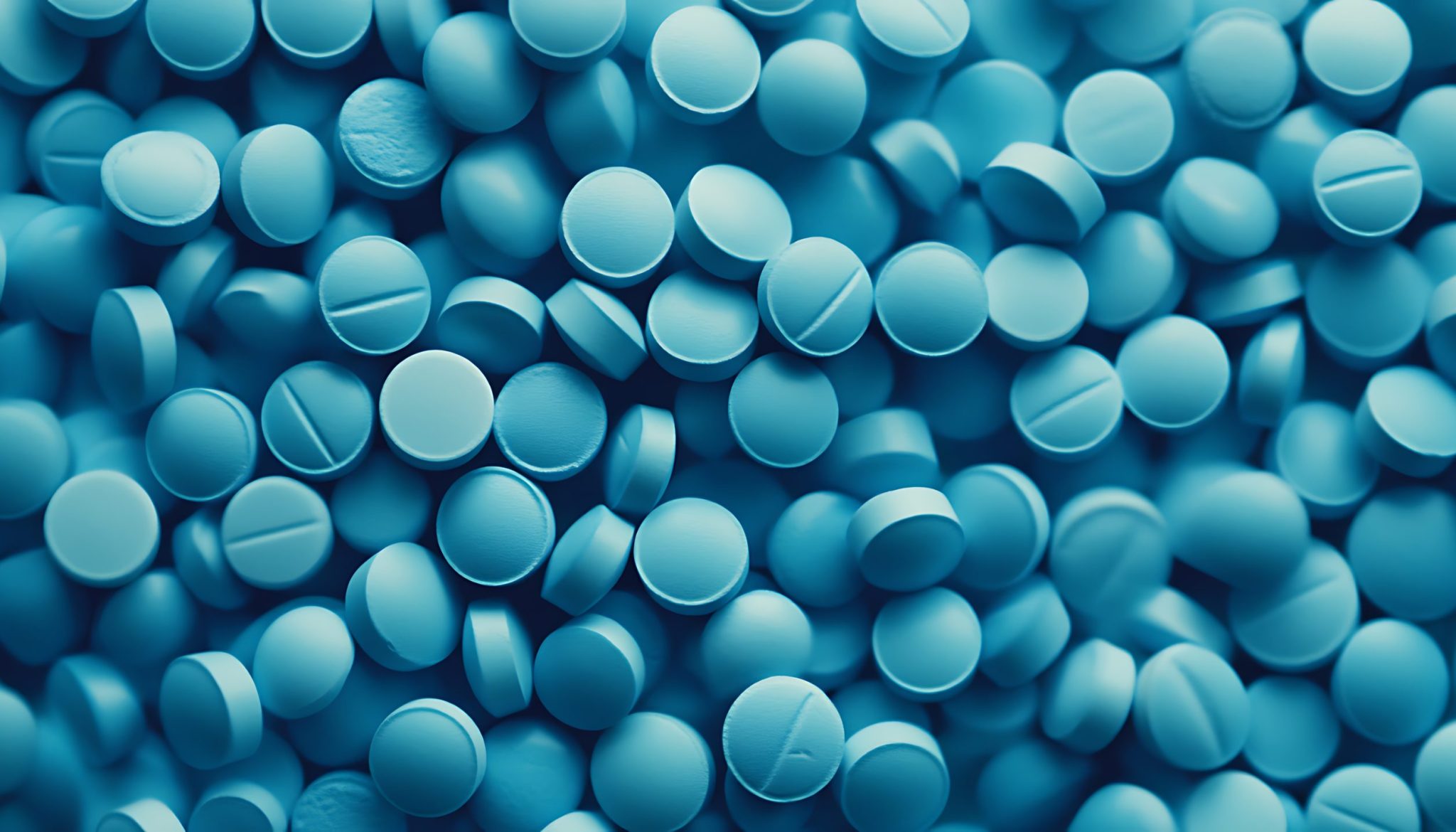 Blue pills on blue background. Top view