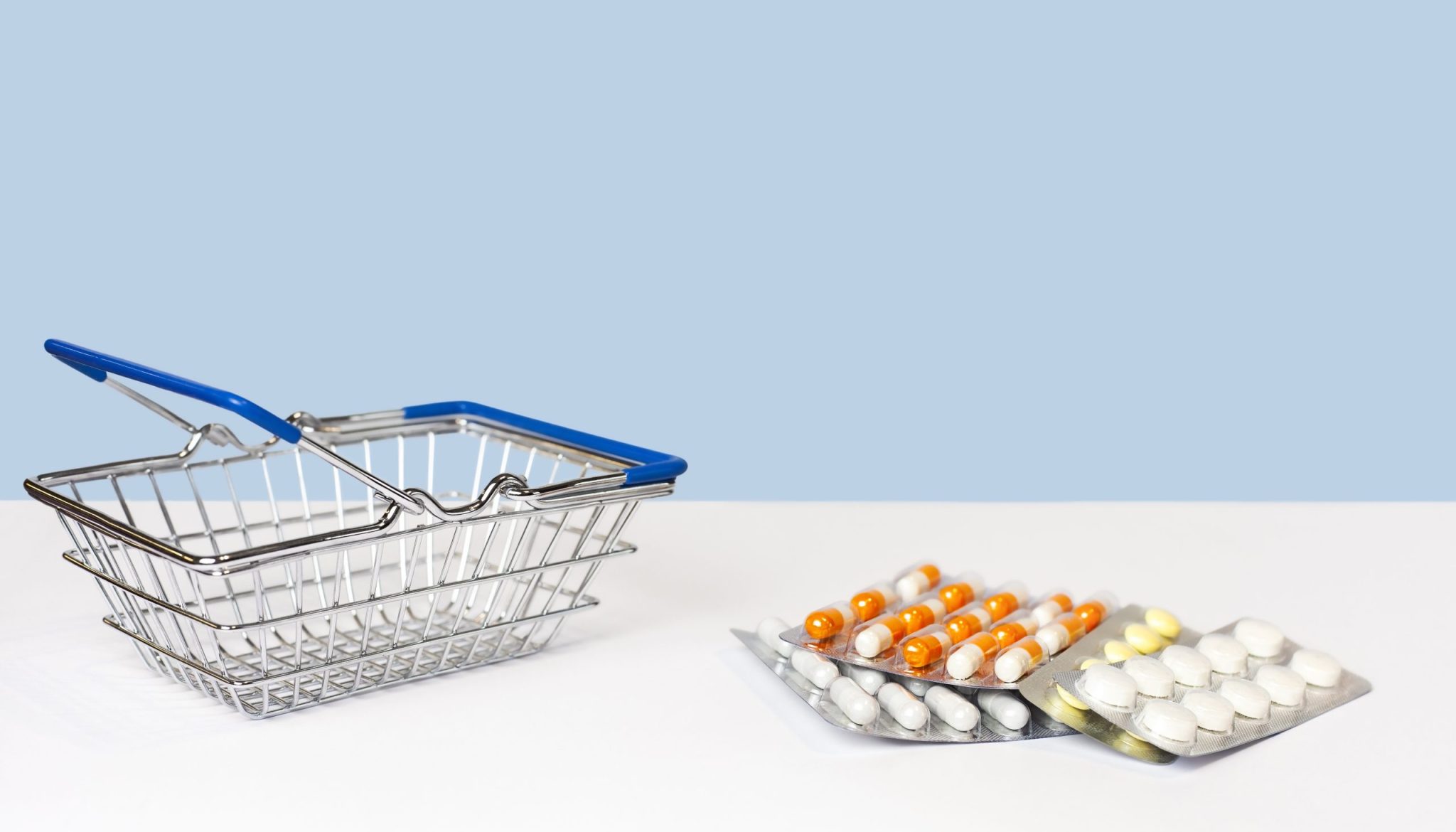 shopping-cart-pills-lie-table-blue-background