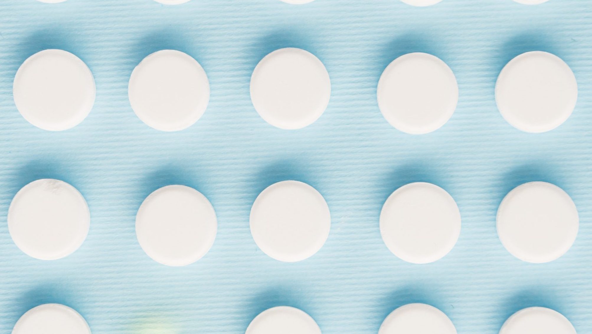Top view of white pills with one green capsule isolated