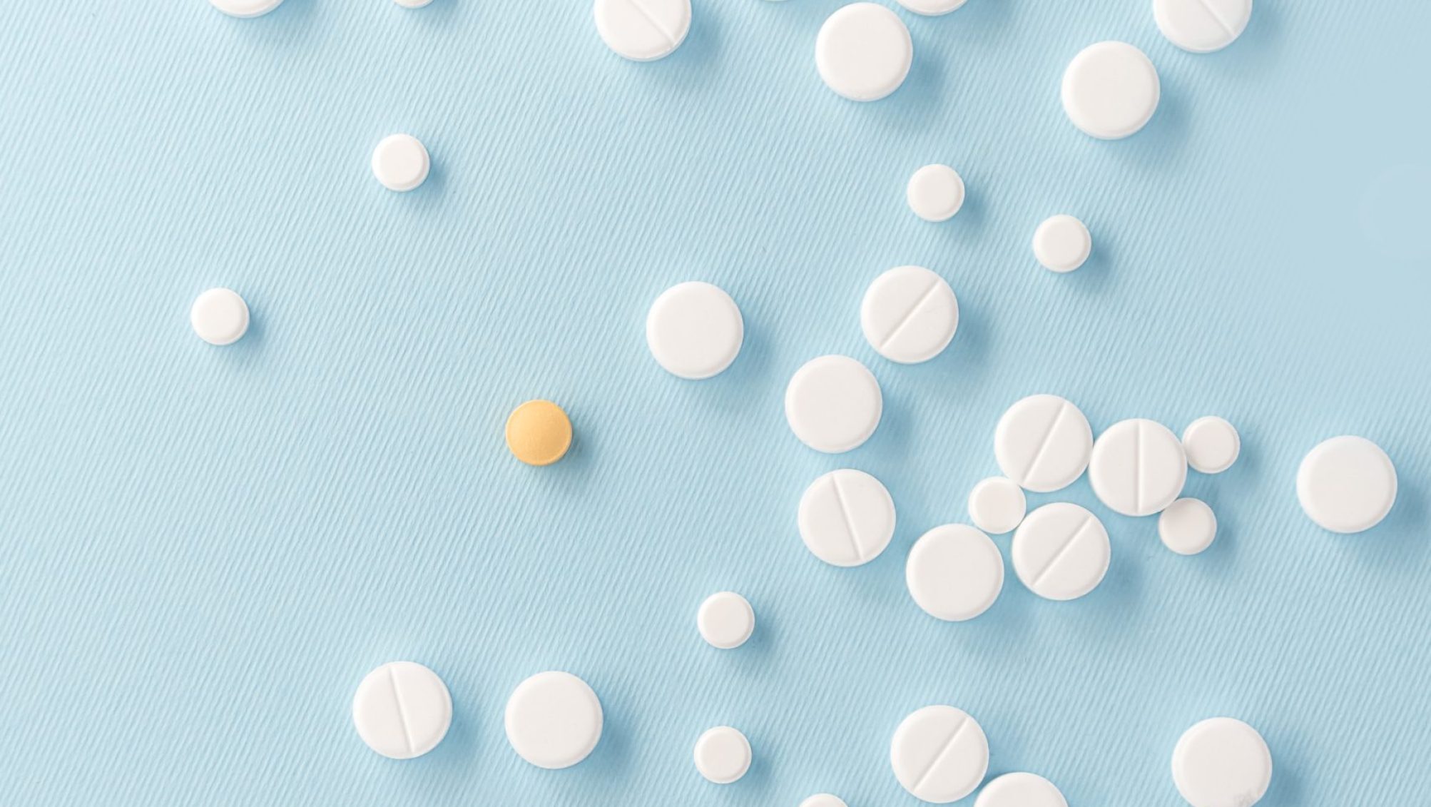 Top view of white pills with yellow tablet isolated